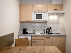 een keuken met een spoelbak en een magnetron bij The River by Regina in Sölden