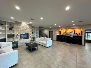 a living room with two couches and a man walking through it at Country Inn & Suites by Radisson, Chicago O'Hare South, IL in Bensenville