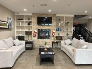 a living room with two couches and a brick wall at Country Inn & Suites by Radisson, Chicago O'Hare South, IL in Bensenville