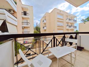 - un balcon avec deux chaises blanches et une table dans l'établissement Omorfokklisias by Verde Apartments, à Athènes