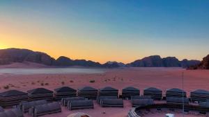 a group of tents in the desert at sunset at Wadi Rum Majestic Camp in Wadi Rum