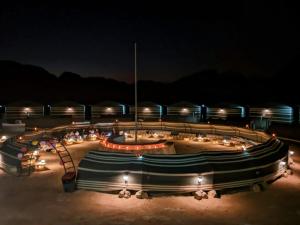 a group of benches in the sand at night at Wadi Rum Majestic Camp in Wadi Rum