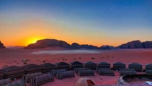 a group of tents in the desert at sunset at Wadi Rum Majestic Camp in Wadi Rum