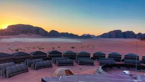 a group of tents in the desert at sunset at Wadi Rum Majestic Camp in Wadi Rum