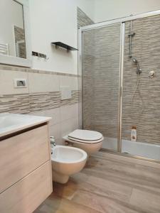 un bagno con wc e doccia in vetro di Appartamento al parco con parcheggio gratuito a Orbetello