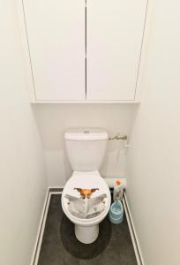 a small bathroom with a toilet with a dog on the seat at Cosy 2 pièces proche de Paris avec parking in Gentilly +4 photos