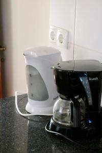 eine Kaffeemaschine, die auf einer Theke neben einem Mixer steht in der Unterkunft Mountain View Villa in São Vicente