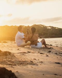 un hombre y una mujer sentados en la playa en Redário Pôr Do Sol - Hospedagem e Experiência no Marajó, en Soure