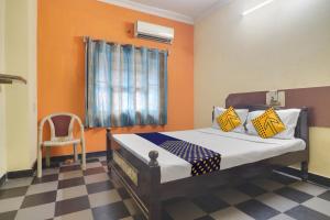 a bedroom with a bed with orange walls and a checkered floor at SPOT ON New Balaji Residency in Hyderabad +19 photos
