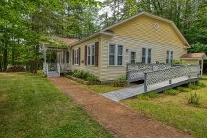 a yellow house with a porch and a fence at Rockwell Falls Inn and Wine Bar in Lake Luzerne