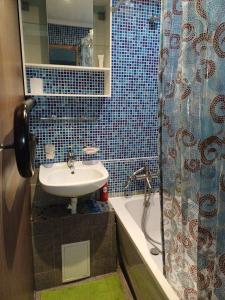 un baño con lavabo y bañera en Inzenieru 77 apartment, en Ventspils