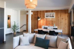 a living room with a couch and a table at Résidence Les Suites Du Ferret in Cap-Ferret