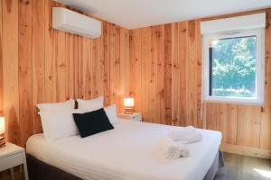 a bedroom with a bed with two towels on it at Résidence Les Suites Du Ferret in Cap-Ferret