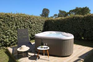 a hot tub with two chairs and a bottle of wine at Résidence Les Suites Du Ferret in Cap-Ferret