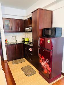 a kitchen with a microwave and a refrigerator with a fish on it at Mariners Cabin Apartment in Nuwara Eliya