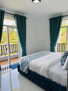 a bedroom with a bed with green curtains and a balcony at Mariners Cabin Apartment in Nuwara Eliya