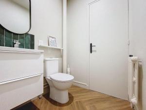 a white bathroom with a toilet and a mirror at Au cœur du centre historique in Caen +9 photos