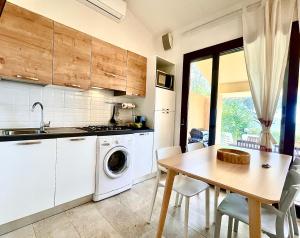 a kitchen with a table and a washing machine at Dimora Simius in Villasimius