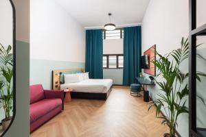 ein Hotelzimmer mit einem Bett und einer Couch in der Unterkunft CX Milan Bicocca in Mailand