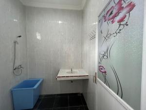 图克图克Hisar Guest House的浴室设有水槽和墙壁上粉红色花卉淋浴。