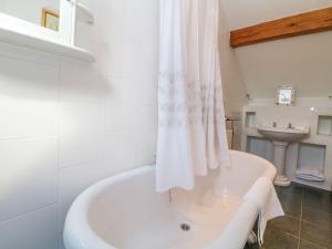 a white bath tub in a bathroom with a sink at School House Cottage in Buxton +14 photos