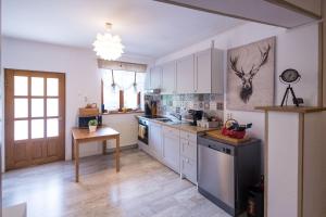 a kitchen with white cabinets and a stove top oven at Cuibul Zăganului - Relax, Sauna & SPA in Cheia