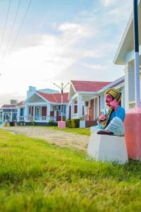 a statue of a man playing a saxophone in front of houses at Mamalla Kudil Resort in Mahabalipuram