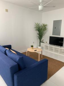 a living room with a blue couch and a table at Arecibo Hotel 2104 in Arecibo