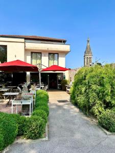 a restaurant with tables and umbrellas and a building at Le Clos Jeannon in Nancy