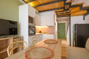 a kitchen with a wooden table and a refrigerator at theopisti home in Ouranoupoli