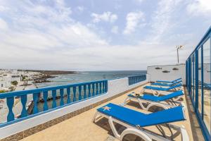 a balcony with blue chairs and the ocean at Casa Azul by Escape Home in Punta de Mujeres