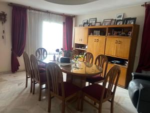 Una mesa de comedor y sillas en una sala de estar. en La Maison de Marinés, en Villa Nueva