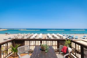 a balcony with a table and chairs and a beach at Ekati Seaside Living in Kolymvari
