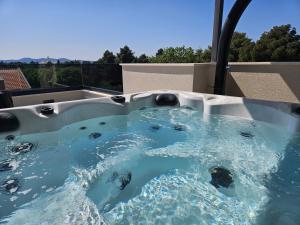 a jacuzzi tub with blue water in it at Azzurro apartment - with private rooftop jacuzzi in Zadar