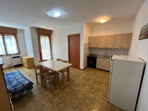 a kitchen with a table and a refrigerator at Condominio Simma in Bibione