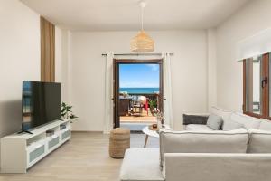a living room with a couch and a tv at Ekati Seaside Living in Kolymvari