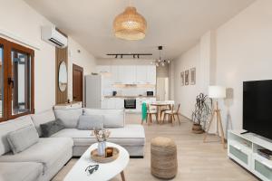 a living room with a couch and a tv and a table at Ekati Seaside Living in Kolymvari