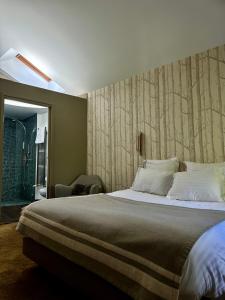 a bedroom with a large bed with a wooden wall at Le Clos Jeannon in Nancy +7 photos