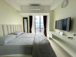a bedroom with a bed and a flat screen tv at Apartement Studio Pollux Habibi Batam A13715 HOT PROMOTION WITHOUT WIFI in Batam Center +21 photos