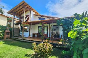 a house with a porch and a patio at Casa Aruanã - Praia do Sargi, Serra Grande in Uruçuca