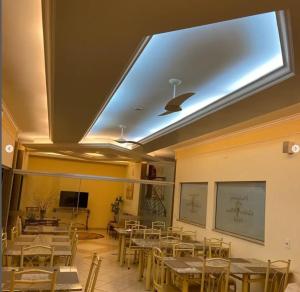 a dining room with tables and chairs and a skylight at Pindorama Golden Plaza Hotel - Pindorama SP in Catanduva