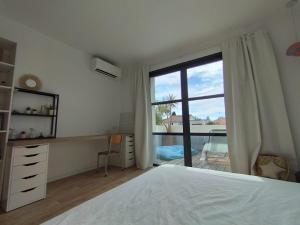 una camera da letto con un letto e una grande finestra di Villa Golf LGM a La Grande-Motte Altre 44 foto