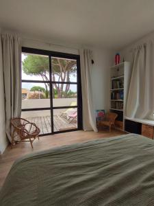 una camera da letto con un letto e una porta scorrevole in vetro di Villa Golf LGM a La Grande-Motte