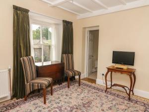 a living room with a piano and chairs and a television at Kearton Shunner Fell in Richmond