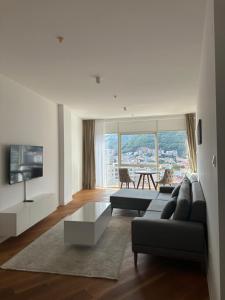 a living room with a couch and a tv at TC BiG APARTMENTS in Budva