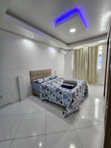 a bedroom with a bed and a blue light at Apartamentos - Repouso do Guerreiro in Itabuna
