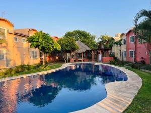 a swimming pool in front of some buildings at Casa con alberca a 8 Min de Playa in Ixtapa