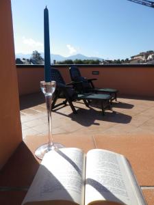 un libro aperto con una candela e un bicchiere di vino di La Terrazza a Lucca