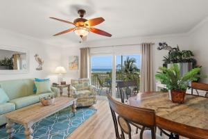 a living room with a ceiling fan and a table at South Beach Condo Hotel by Travel Resort Services, Inc. in St. Pete Beach