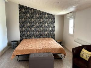 una camera con un letto e una parete con carta da parati ad uccello di Le logis des Lilas a Corme-Royal